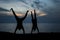 Couple making handstand at the beach during sunset