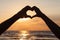 Couple making hear shape at beach