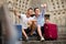 Couple of male tourists with baggage sitting with map at stairs