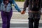 Couple of man and woman holding hands with backpack, on their backs