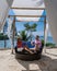 couple man and woman mid age in swimming pool on a luxury vacation in Thailand, men and Asian woman in pool looking out