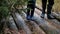 A couple, a man and a woman in rubber boots are walking through the forest.