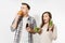 Couple man and woman standing with green detox smoothies, salad in glass bowl, burger, cola in glass bottle isolated on