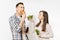 Couple man and woman standing with green detox smoothies, salad in glass bowl, burger, cola in glass bottle isolated on