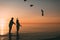 Couple of man and woman standing in the sea and throw your shoes at the beach.