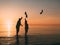 Couple of man and woman standing in the sea and throw your shoes at the beach.