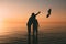 Couple of man and woman standing in the sea and throw your shoes at the beach.