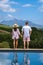 couple man and woman in swimming pool looking out over the Vineyards and mountains of Stellenbosch South Africa