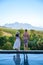 couple man and woman in swimming pool looking out over the Vineyards and mountains of Stellenbosch South Africa