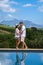 couple man and woman in swimming pool looking out over the Vineyards and mountains of Stellenbosch South Africa