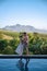 couple man and woman in swimming pool looking out over the Vineyards and mountains of Stellenbosch South Africa