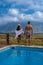 couple man and woman in swimming pool of there lodge on vacation in South Africa looking out over mountains near