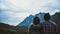 Couple man and woman tourist at top of mountain in Scottish shirt and black hat hiking at mountain peak above clouds and fog Hiker