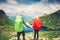 Couple Man and Woman Travelers with backpack holding hands mountaineering