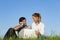 Couple on meadow with laptop and mobile phone