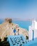 Couple men and woman on vacation Santorini, View to the sea and Volcano from Fira the capital of Santorini island in