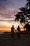 A couple of men and women on the beach watching the sunset during vacation at Aruba Island Caribbean