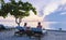 Couple of men and women relaxing by the pool in beach beds chairs, tropical pool