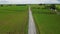 couple men and women walking on a road between green rice field, green rice paddy field in Thailand