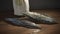 a couple of metal leaves sitting on top of a wooden table next to a vase with a white vase behind it on a wooden table