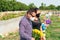 Couple in mourning cemetery holding yellow flowers in their hands