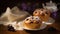 a couple of muffins sitting on top of a plate next to a cup of coffee and a teapot on a tablecloth