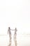 Couple, ocean and holding hands for walk on beach, travel and commitment with trust and bonding outdoor. Love, care and