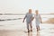 Couple of old mature people walking on the sand together and having fun on the sand of the beach enjoying and living the moment.