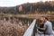 A couple on the old wooden bridge at a lake on autumn day. Forest on background. Happy togather, copy space for text. romantic