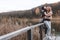 A couple on the old wooden bridge at a lake on autumn day in park. Forest on background. Happy togather, copy space for text.