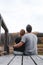 A couple on the old wooden bridge at a lake on autumn day in park. Forest on background. Happy togather, copy space for text.