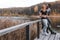 A couple on the old wooden bridge at a lake on autumn day in park. Forest on background. Happy togather, copy space for text.