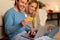 Couple Ordering Shopping Online On Laptop Sitting On Floor Indoor