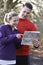 Couple Orienteering In Woodlands With Map And Compass