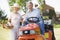 Couple outdoors with tools and lawnmower smiling