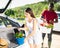 Couple packing harvested vegetables in car trunk