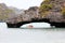The couple paddle kayaking under the stone bridge.