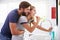 Couple In Pajamas Brushing Teeth In Bathroom