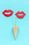 Couple paper lips props on stick in waffle cone on blue background. Concept lesbian love Creative Valentine`s Day