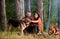 Couple pat german shepherd dog near bonfire, nature background.