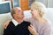 Couple pensioners together on sofa at home