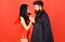 Couple on pensive faces play role game. Devil love concept. Man and woman dressed like vampire, demon, red background