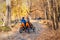 Couple people enjoy riding pedal surrey cart bike rent or sharing outdoors in beautiful golden autumn city park, garden