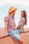 Couple people in western outfits portrait in american countryside farm. Asian woman smiling to young rancher