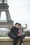 Couple Photographing In Front Of Eiffel Tower