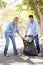 Couple Picking Up Litter In Suburban Street