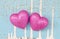 Couple of pink hearts on grungy light blue wood