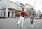 Couple of playful senior women have fun walking along contemporary city street