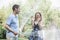 Couple playing with a garden hose and spraying each other outside in the garden