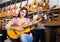 Couple playing guitars in music shop